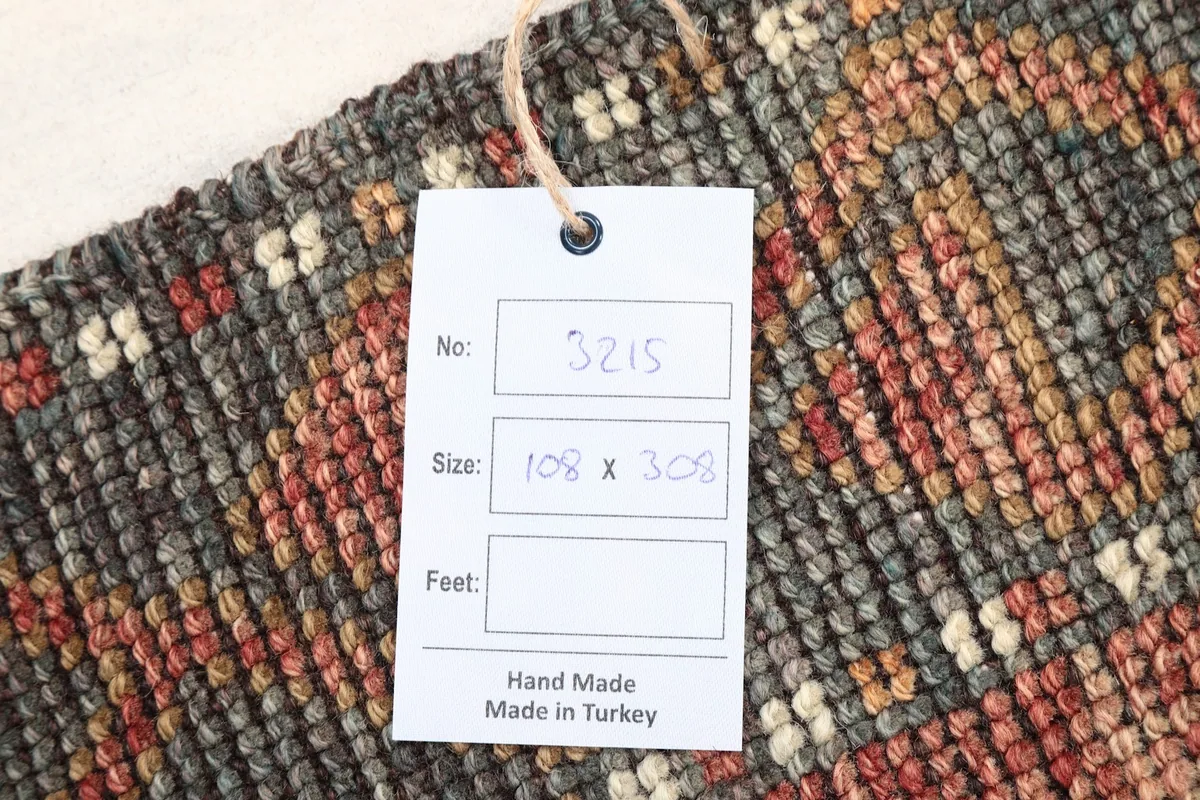 Close-up of the rug's back, showing the tag with size and handmade origin from Turkey