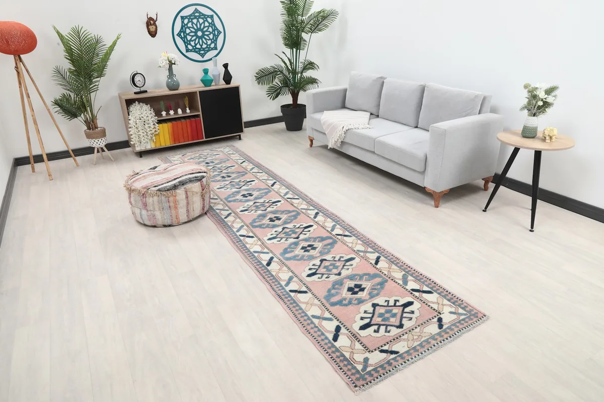 Angle view of the pink runner in a room with a light-colored floor and pouf