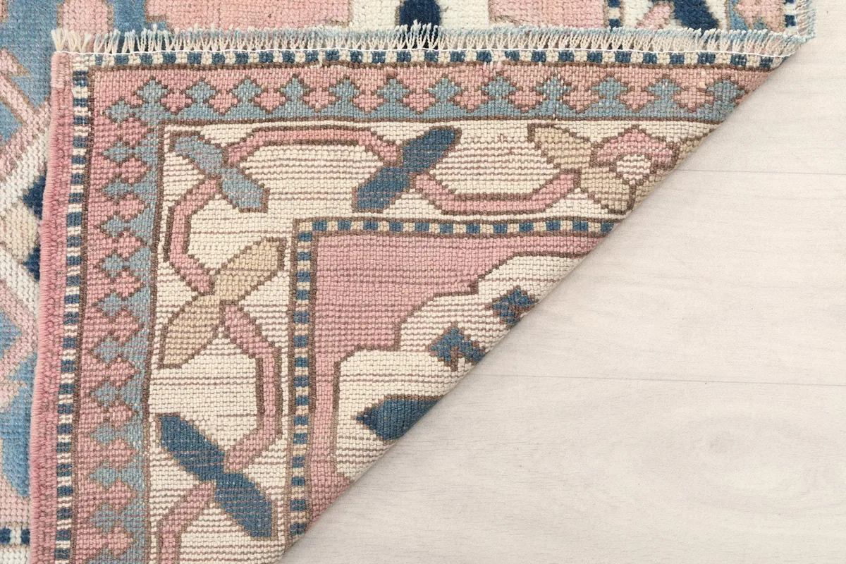 Corner of the rug folded back to reveal the hand-knotted wool pile and cotton foundation