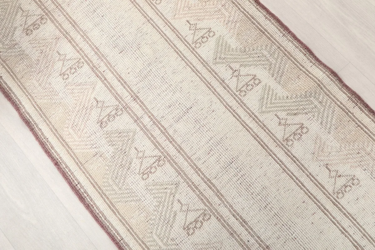 Angled view of the runner rug's central design, showing repeating tribal motifs.