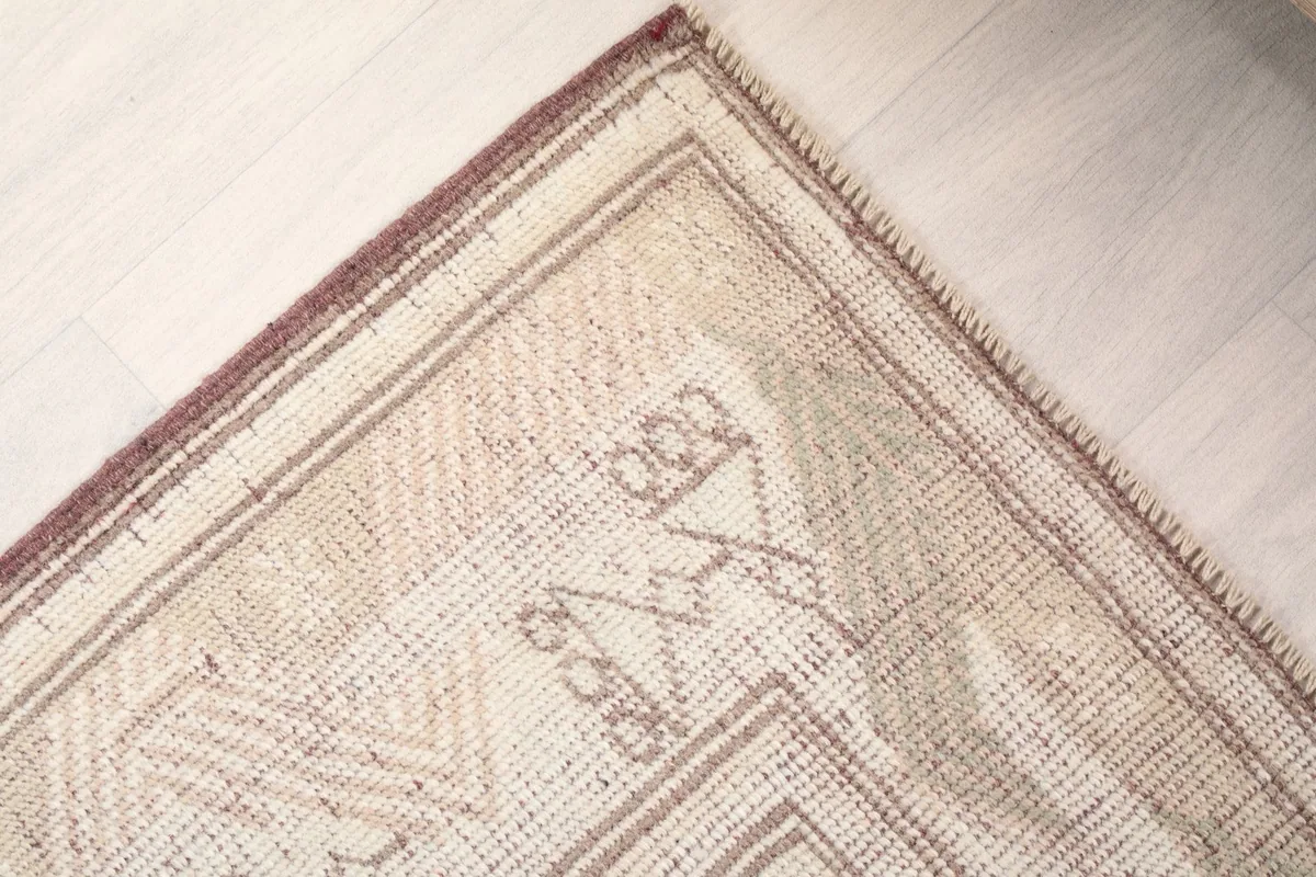 Close-up of the rug's end, emphasizing the hand-knotted wool pile and border details.