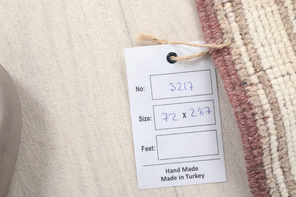 Label showing the rug's unique number and dimensions in centimeters, confirming its origin.