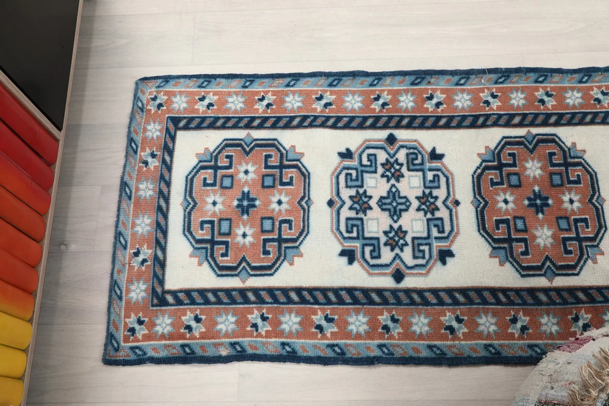 Angle view showcasing three geometric medallions and the distinct borders of the runner rug