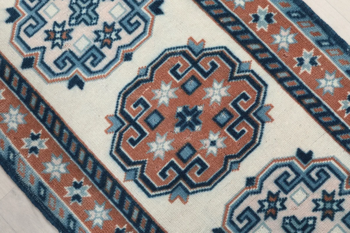 Close-up on an ivory and rust geometric medallion with blue accents in the center
