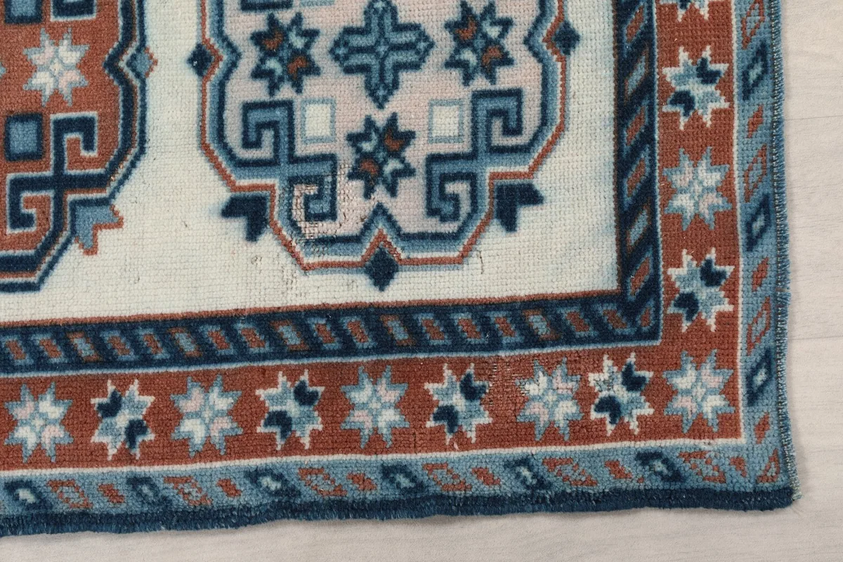 Detailed view of the corner showing the rust and blue borders with star-like motifs