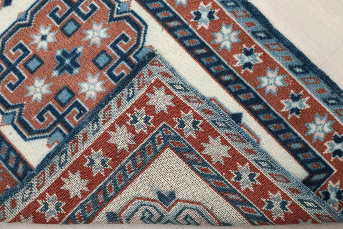 Underside of the hand-knotted wool runner rug, showing the cotton foundation and construction