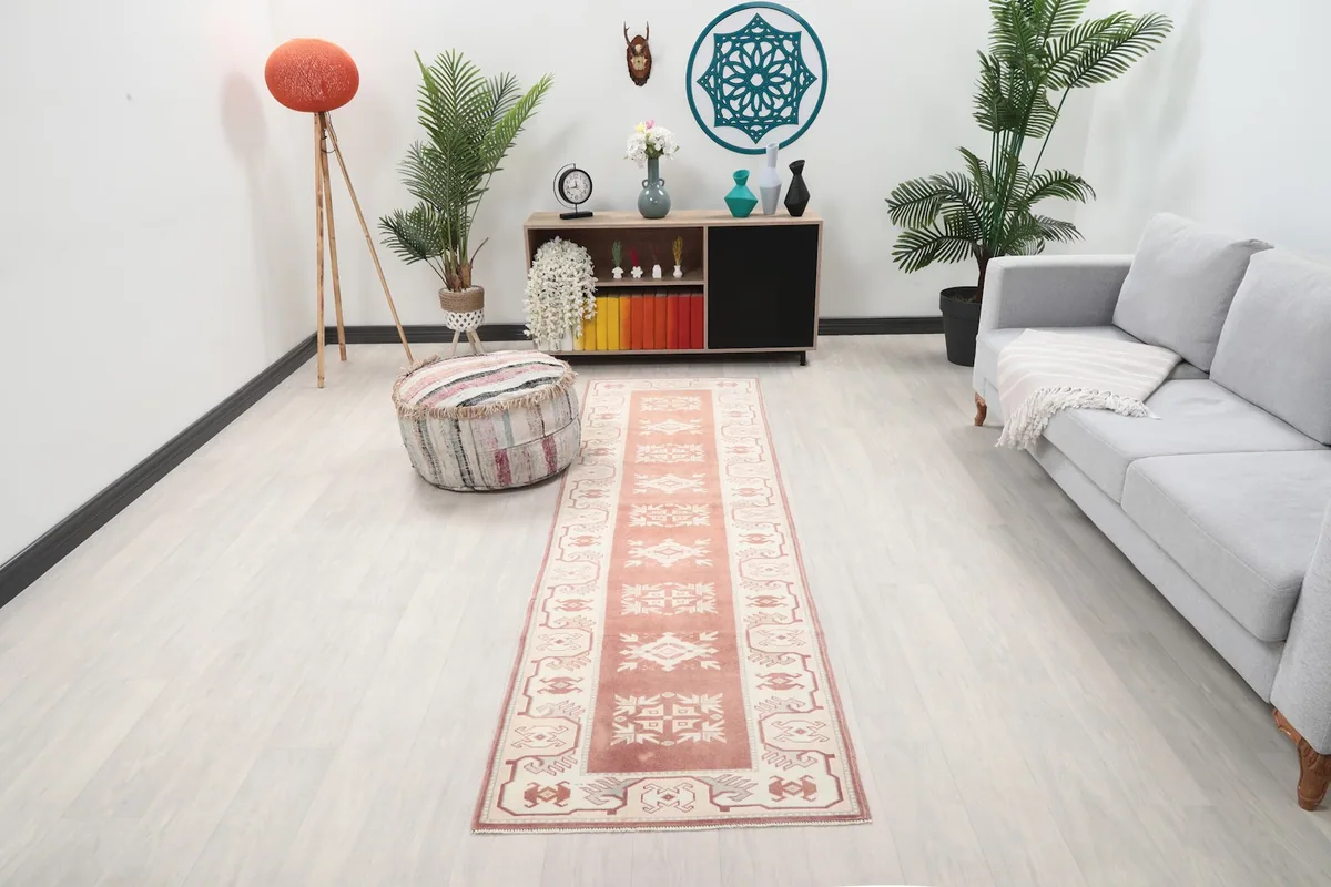 Vintage runner rug in a modern living space with couch and plants, showing its full length