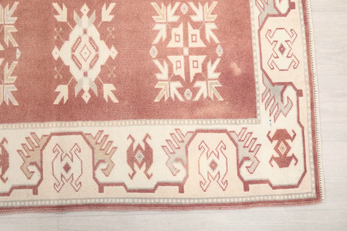 Detail of the runner's corner, showing rose field and ivory geometric border