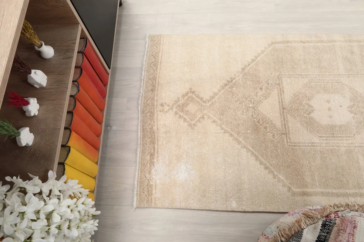 Angled view of the rug on the floor, showing its rectangular shape and faded colors.