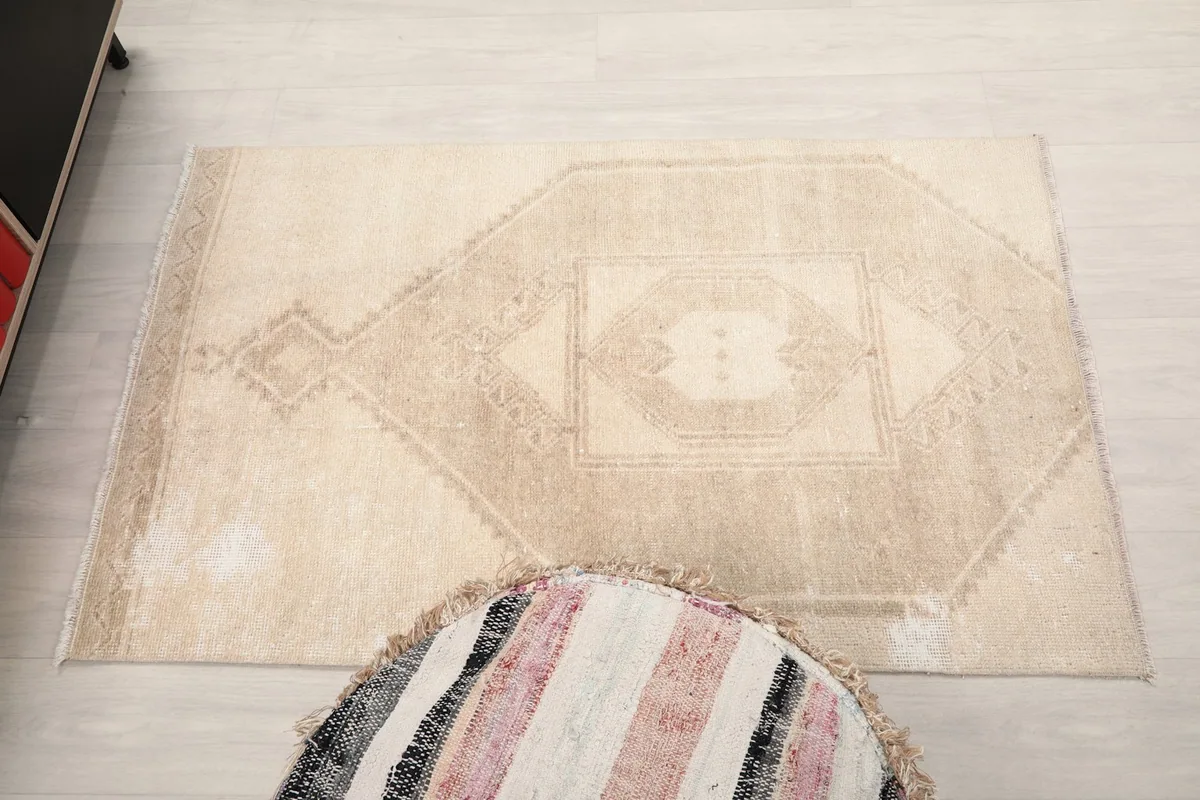 Overhead perspective of the beige area rug, emphasizing its overall shape and geometric pattern.