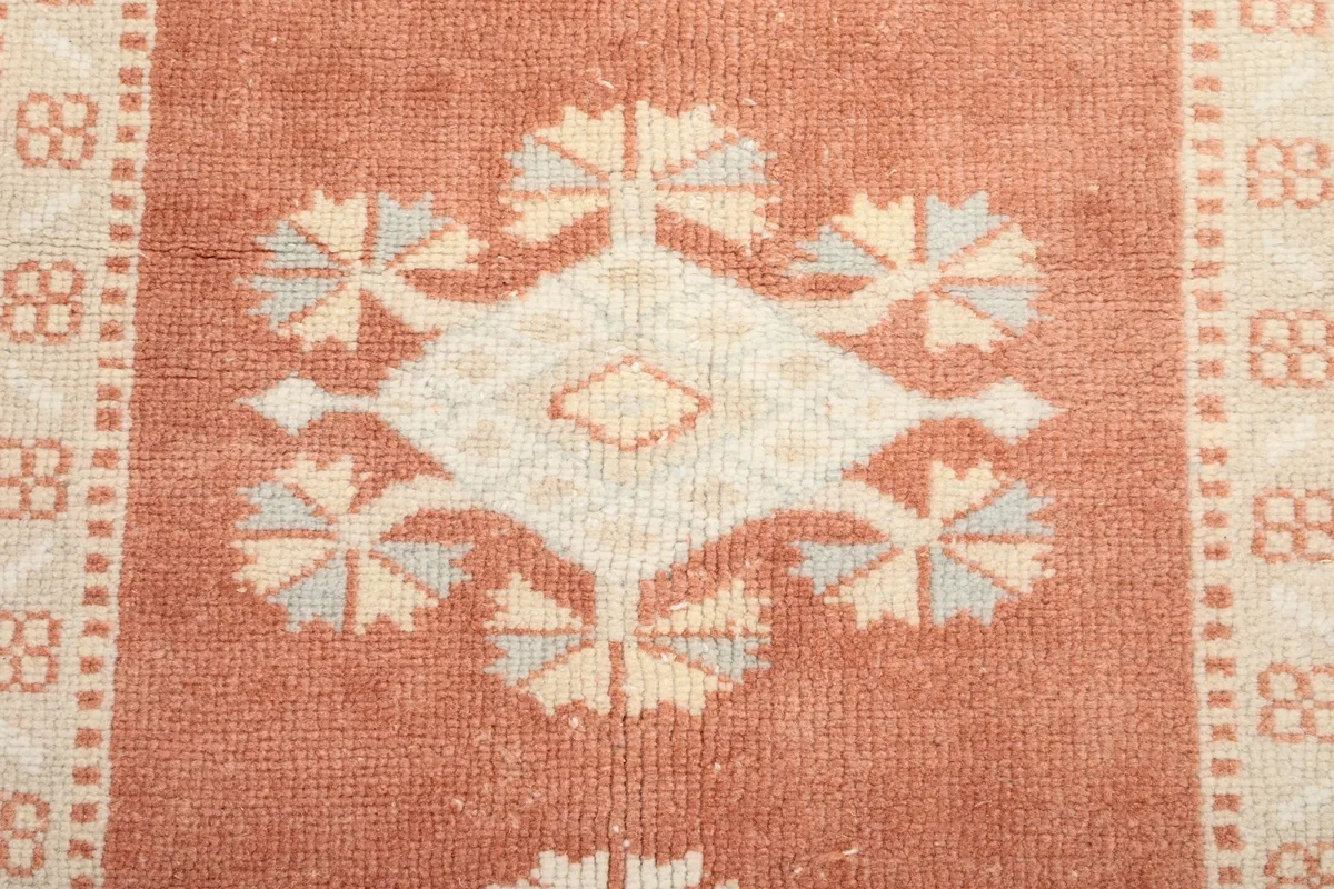 Close-up of a central motif within the rust medallion, showing wool texture