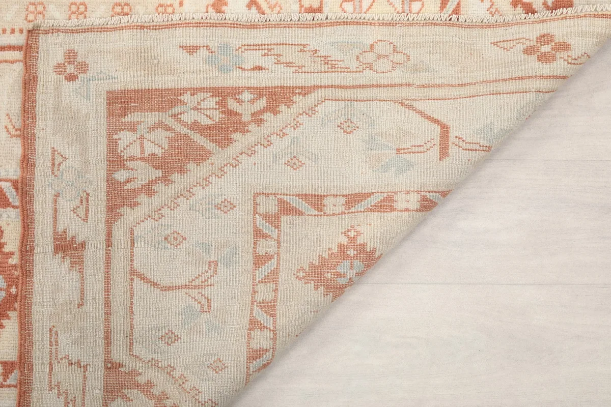 Underside of the rug at a corner, revealing the hand-knotted wool pile on cotton foundation