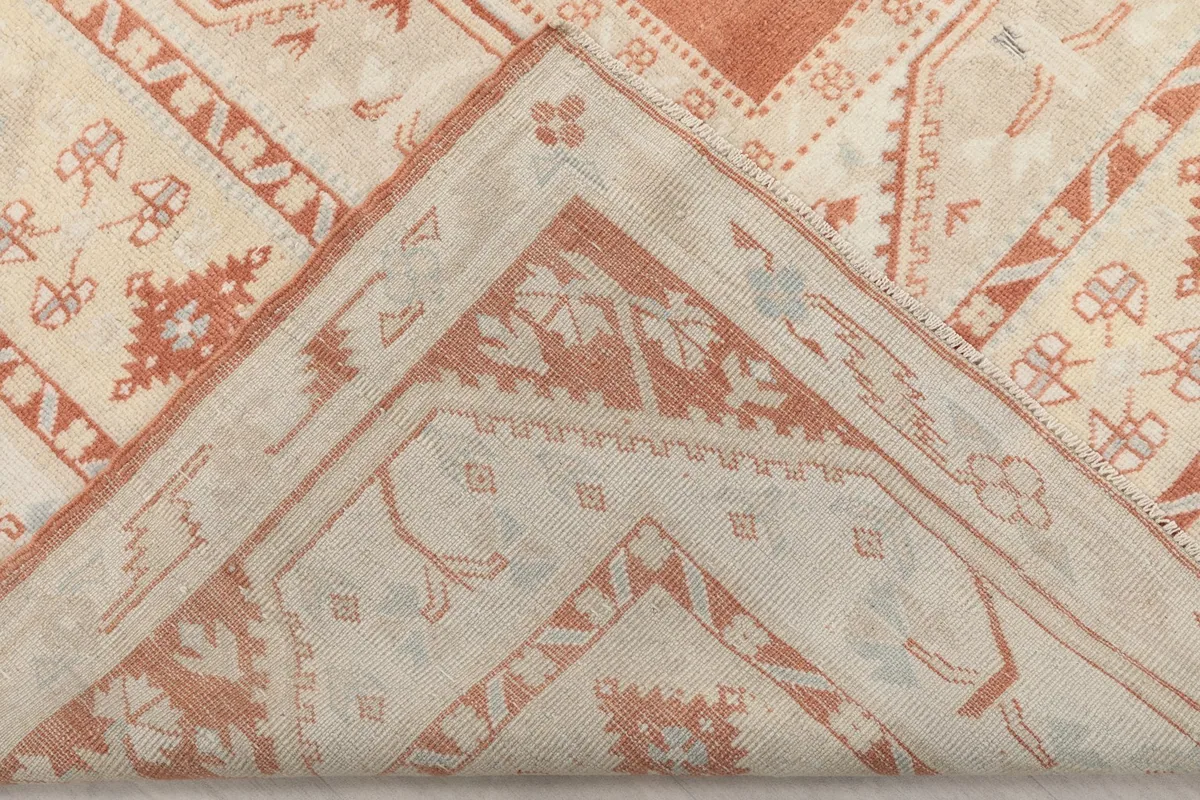 View of the rug folded back, showing the cotton foundation and reverse side of the knots