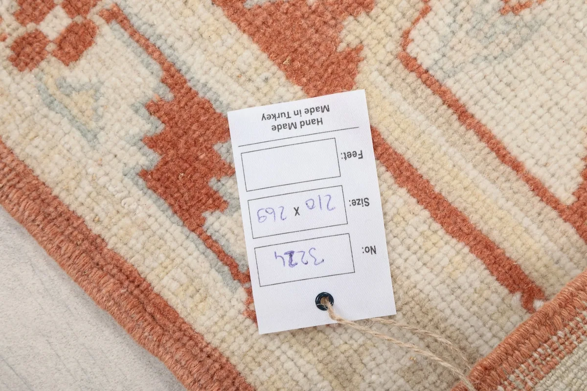Product tag on the rug showing its dimensions 210 x 269 cm and hand-made origin