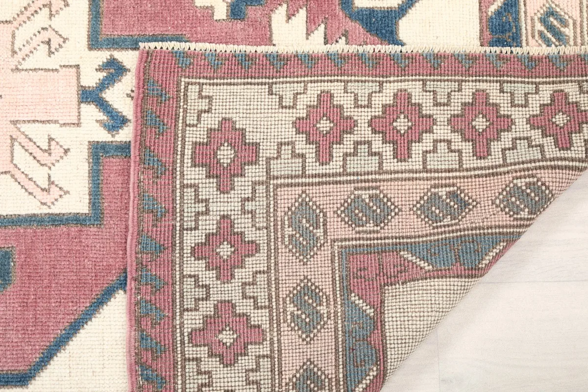 Another folded corner view of the rug, showing the reverse side and knotting detail