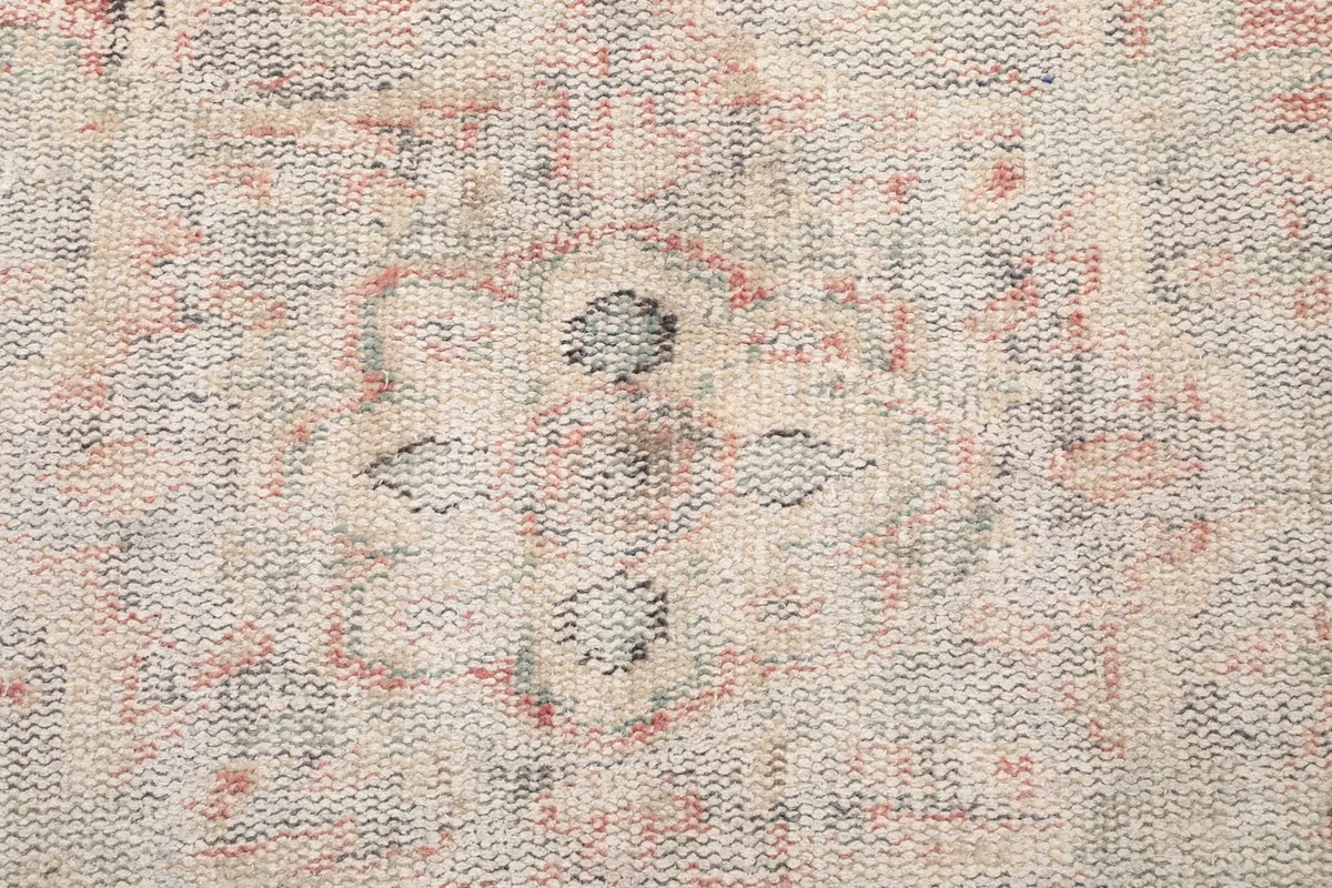 Extreme close-up view of the low pile and intricate knotting of the vintage wool rug
