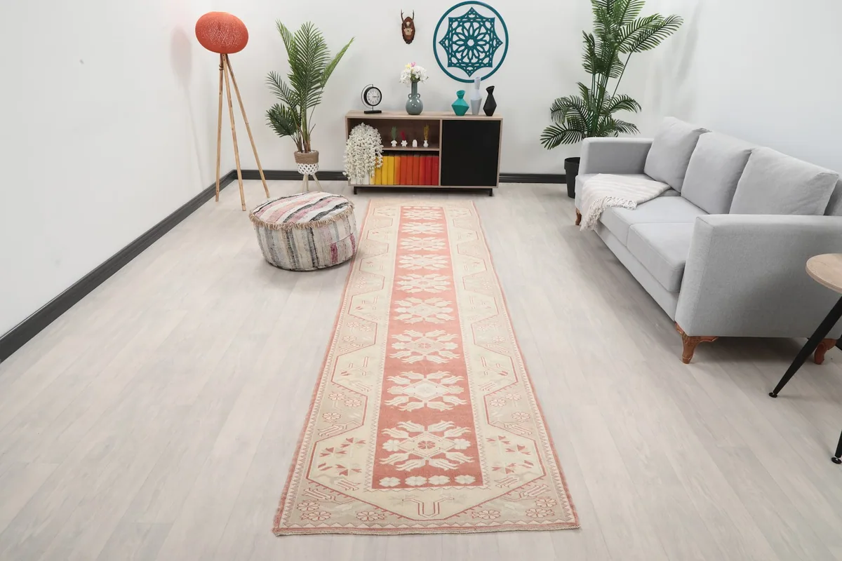 Vintage Anatolian runner rug with rose and ivory colors displayed in a modern living room setting.