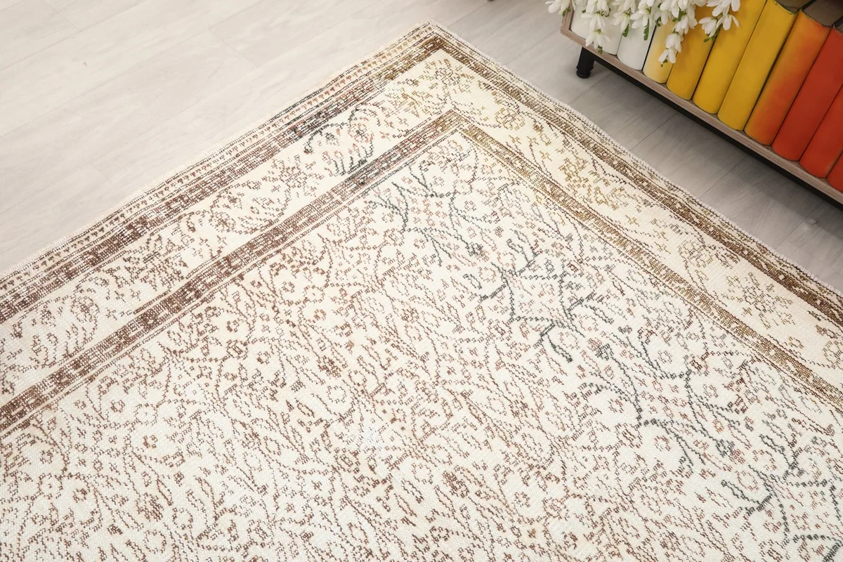 Corner view of the vintage rug, showcasing its aged appearance and patterned border