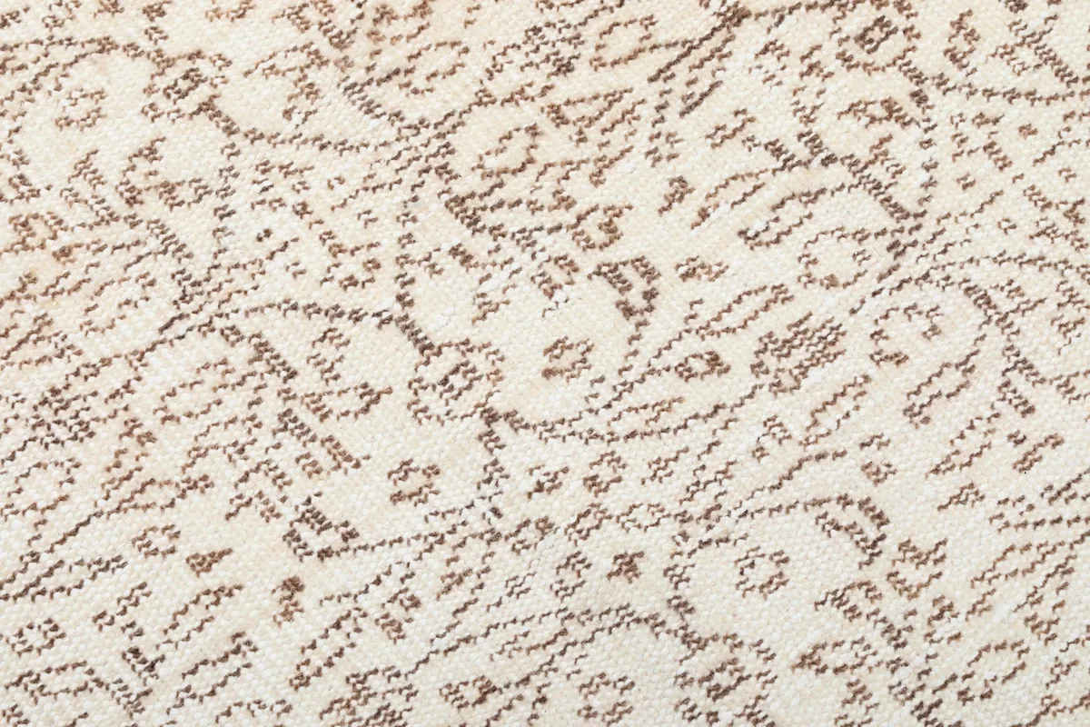 Macro detail of the hand-knotted wool pile, showing the texture and faded brown motifs