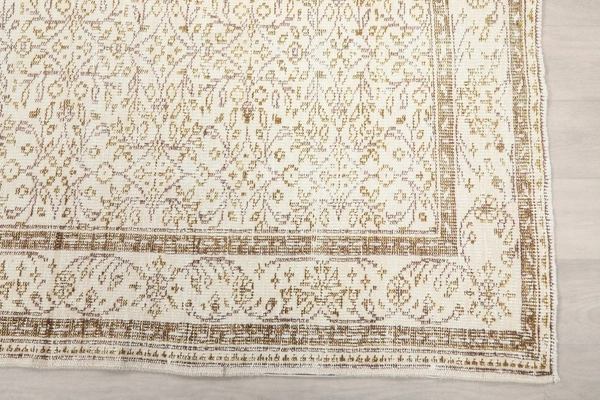 Detailed view of the rug's brown border design with subtle fading and wear