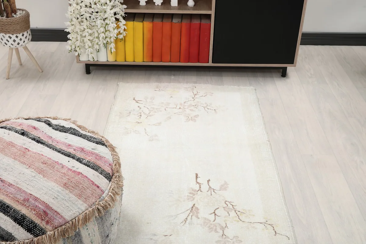Ivory vintage runner rug in a room setting, viewed from above, showing its placement relative to furniture.