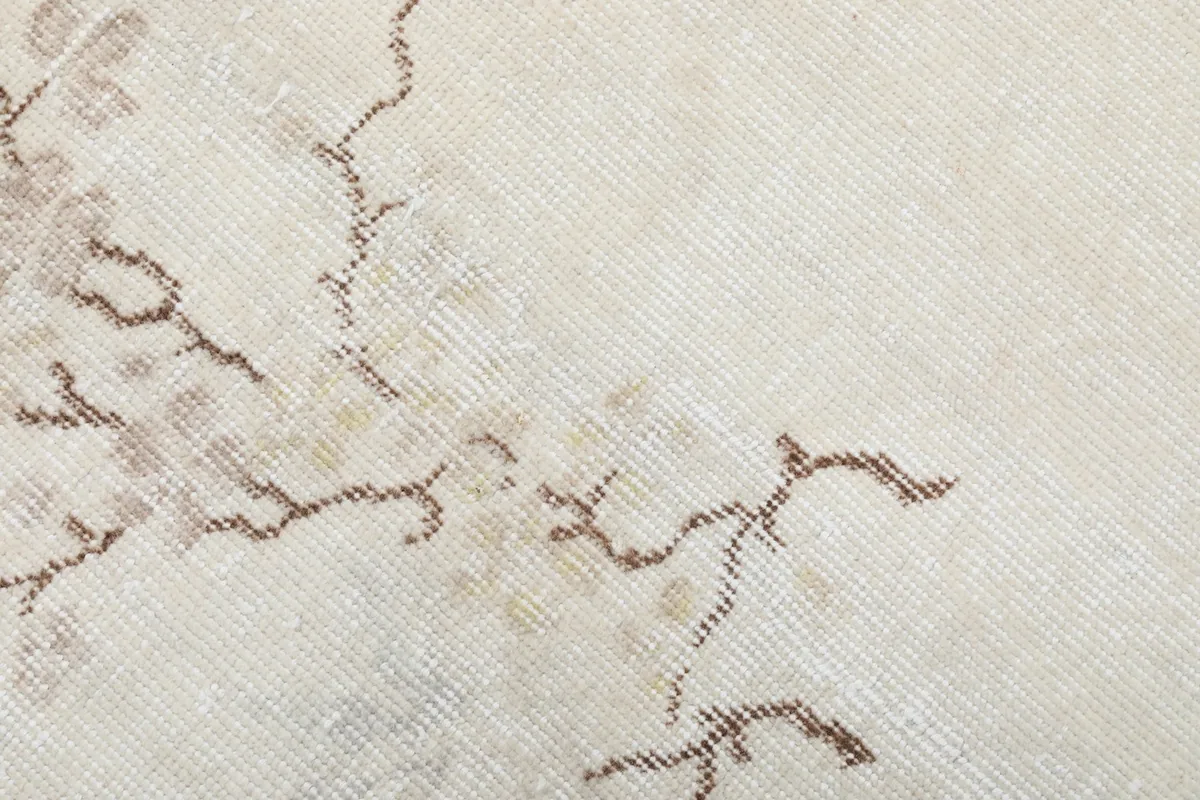 Close-up of the rug's surface, revealing the hand-knotted wool pile and the intricate weaving of the branch motif.