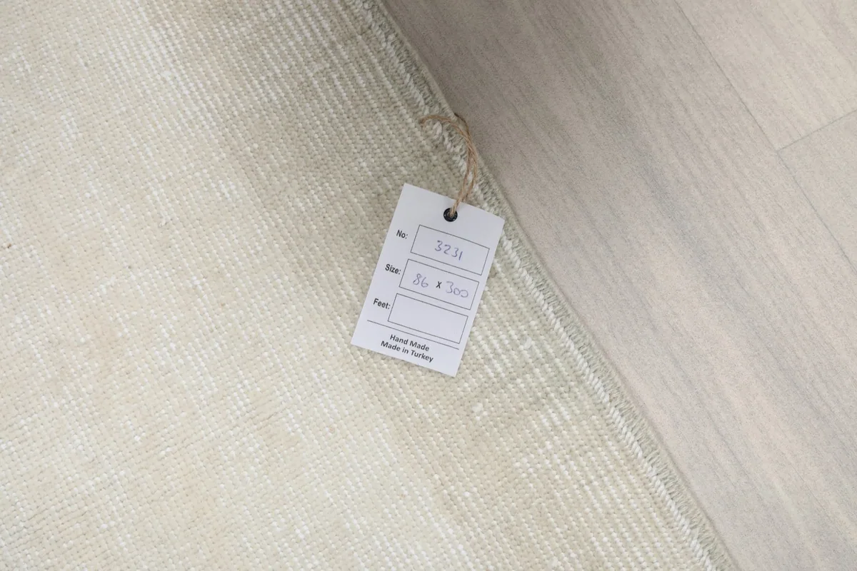Product tag attached to the rug, displaying size information and origin (Hand Made in Turkey).