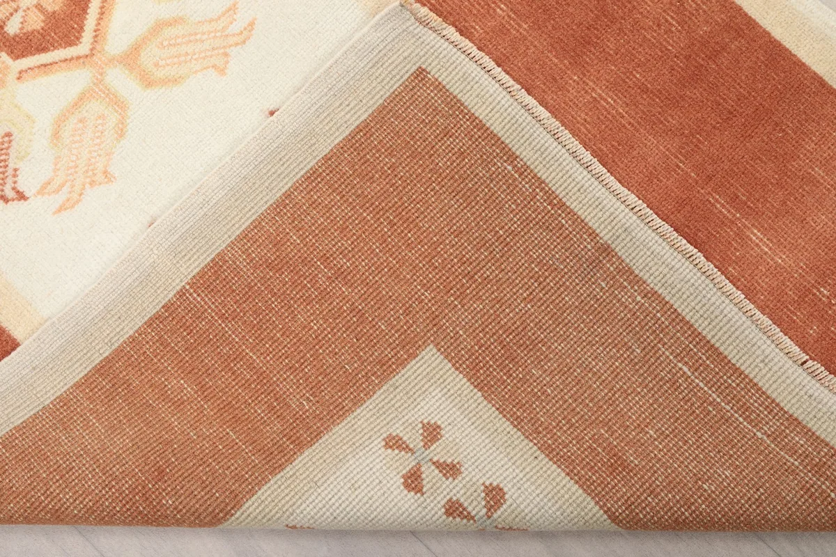 Folded corner of the rug, showing the reverse side and knotting structure