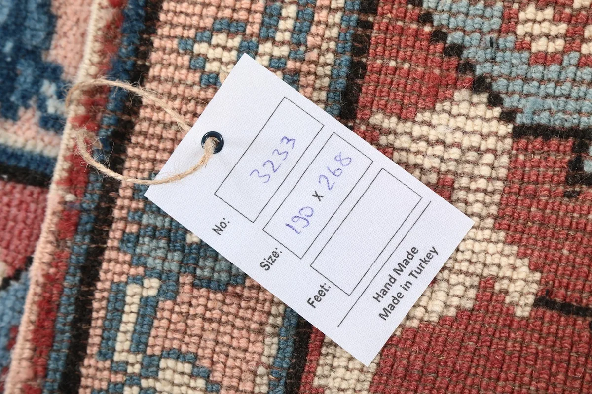 Close-up of the product tag attached to the rug, displaying item number and size in centimeters.