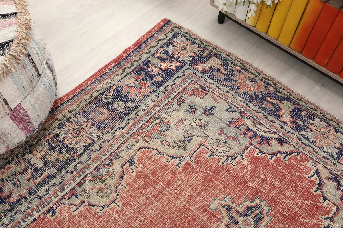 Corner view of the vintage rug, highlighting the border and field colors