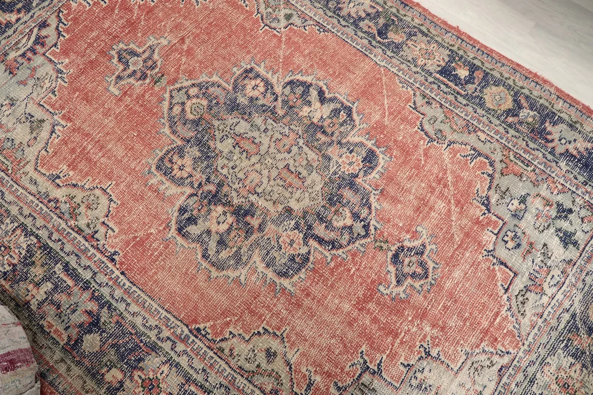 Close-up of the central medallion design with navy, rust, and beige tones