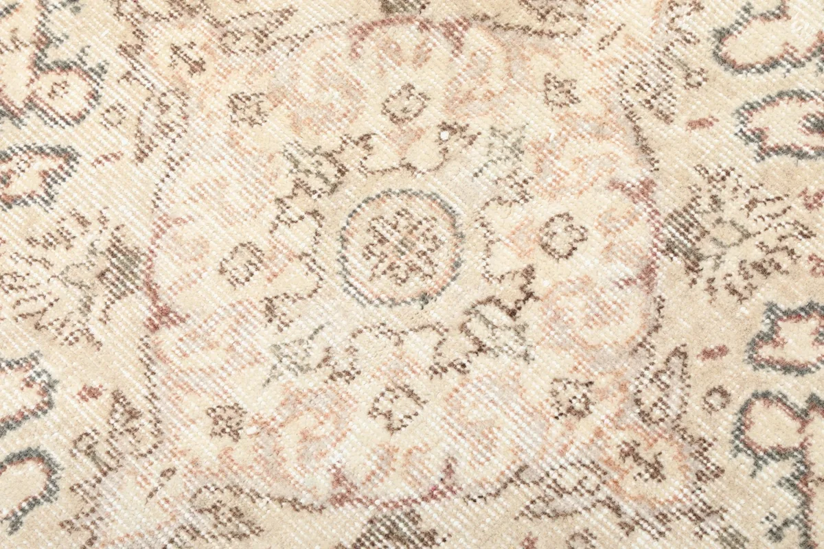 Close-up of the faded central medallion and surrounding patterns, showing subtle color variations
