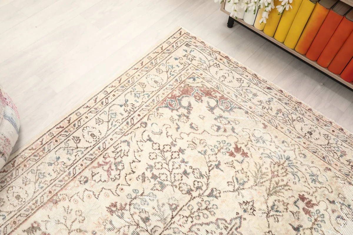 Corner detail of the rug, illustrating the border design and the soft, distressed appearance of the pile