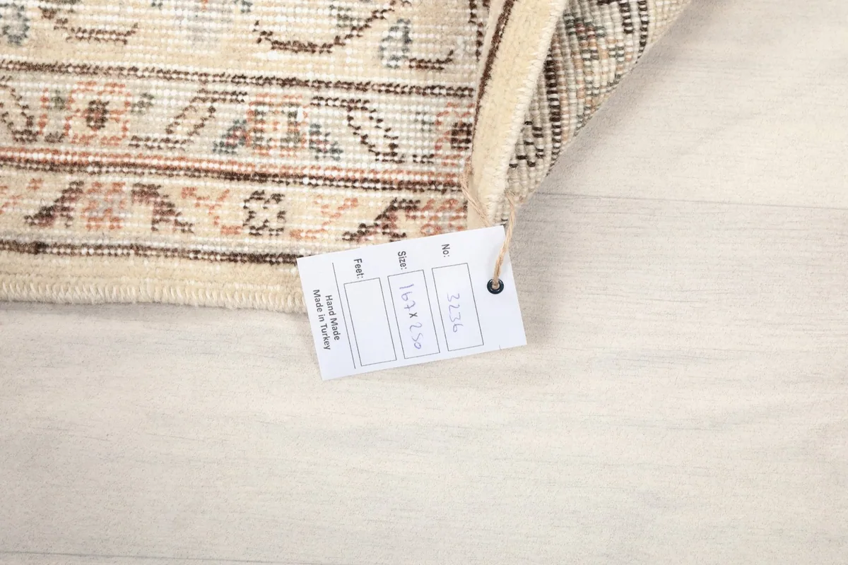 Rug corner with a tag showing the dimensions 5'6" x 8'2" (167 x 250 cm)
