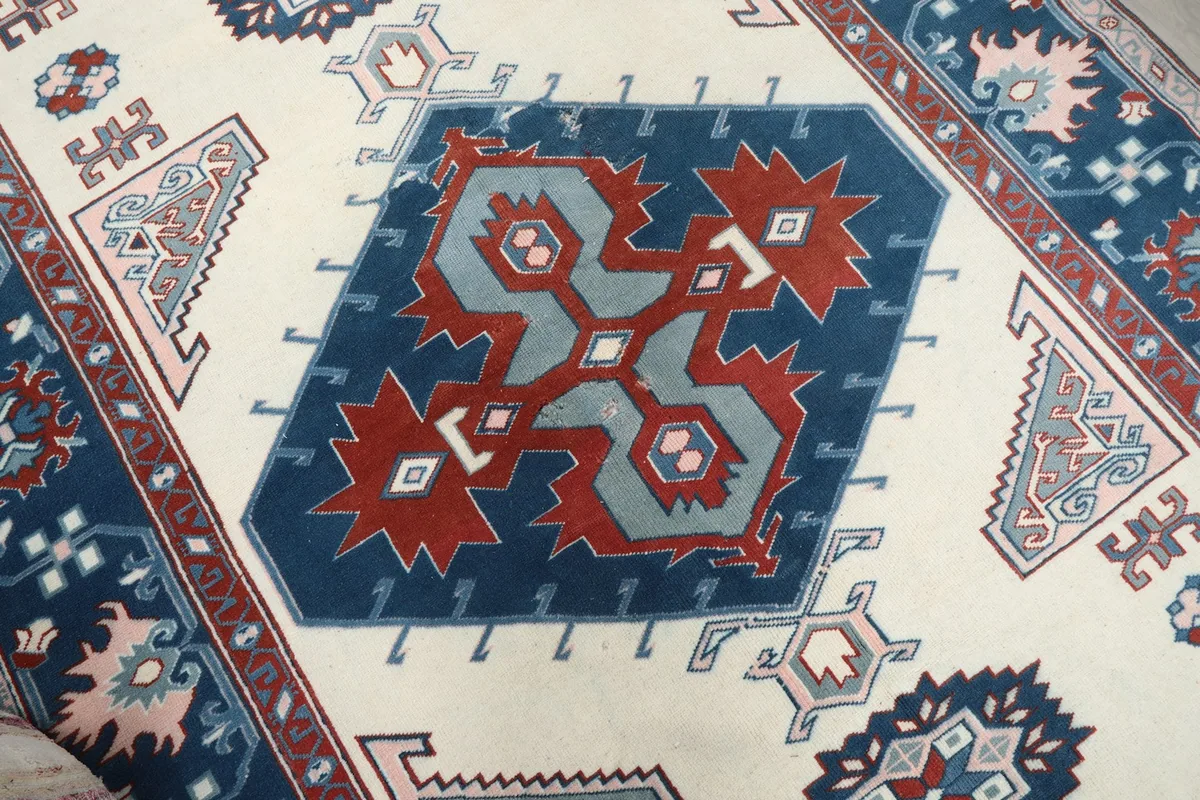 Close-up of the central geometric medallion featuring navy, rust, and blue tones