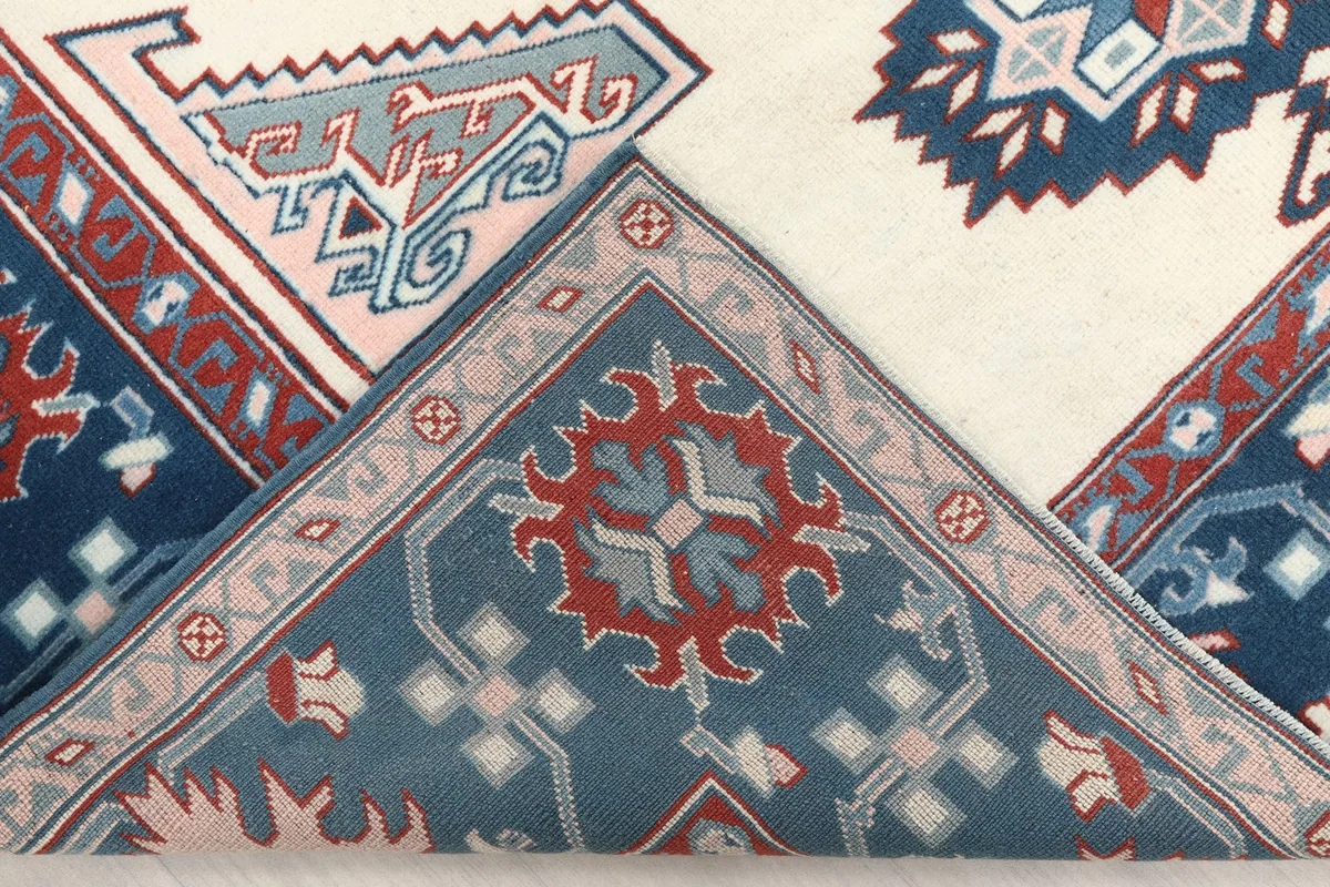 View of the rug folded to show the back of the hand-knotted construction