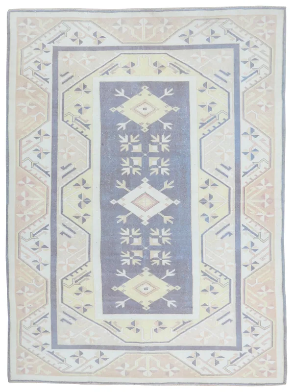 Full overhead view of a blue and beige geometric vintage Anatolian rug on a white background.