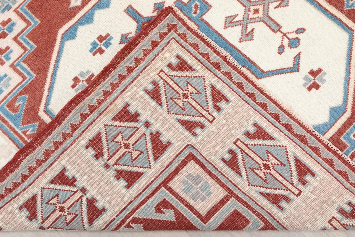 Folded corner of the Rust Ivory Geometric Anatolian Rug, revealing the back and pile thickness