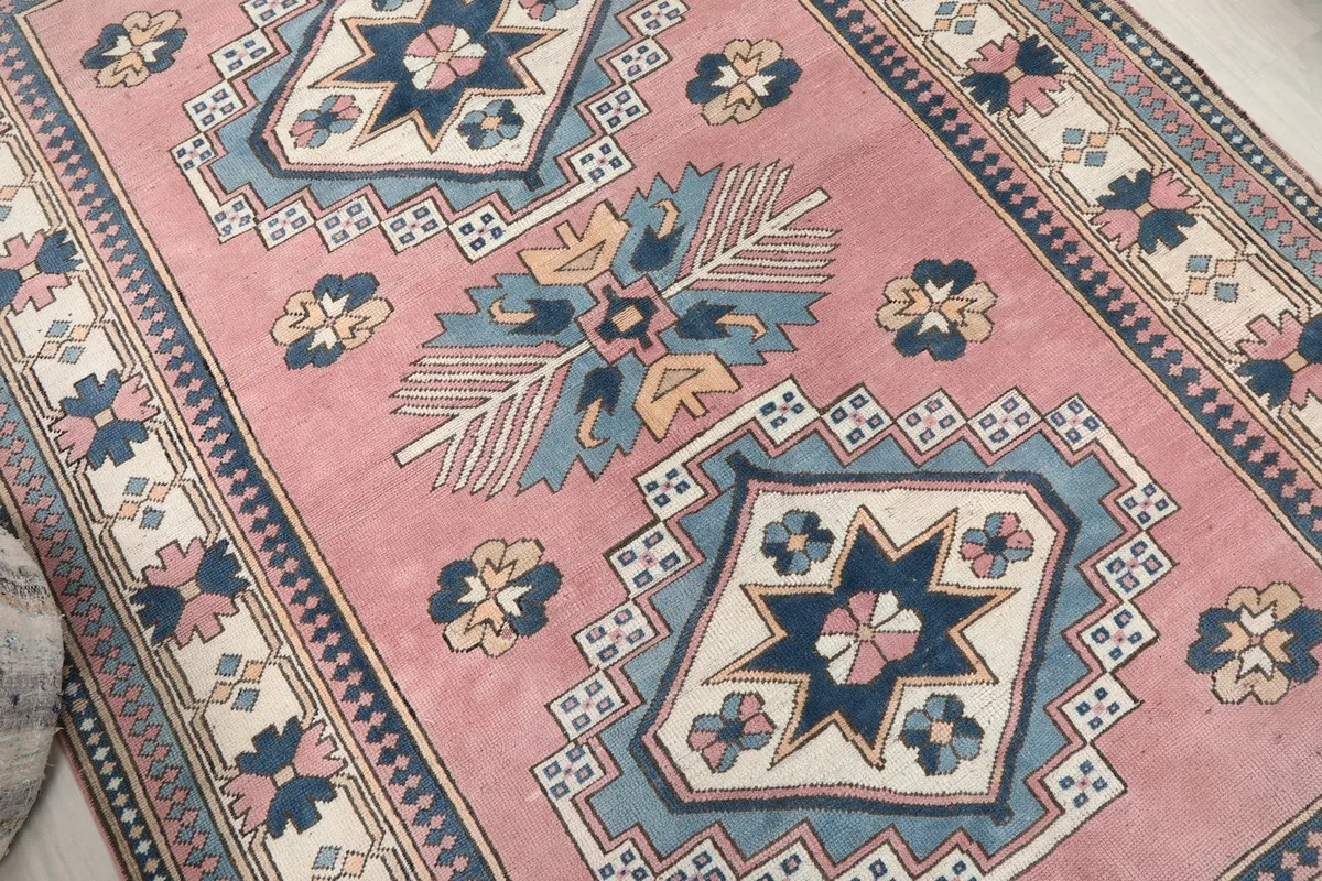Close-up of the geometric patterns and colors within the rug's central design, highlighting the wool pile.