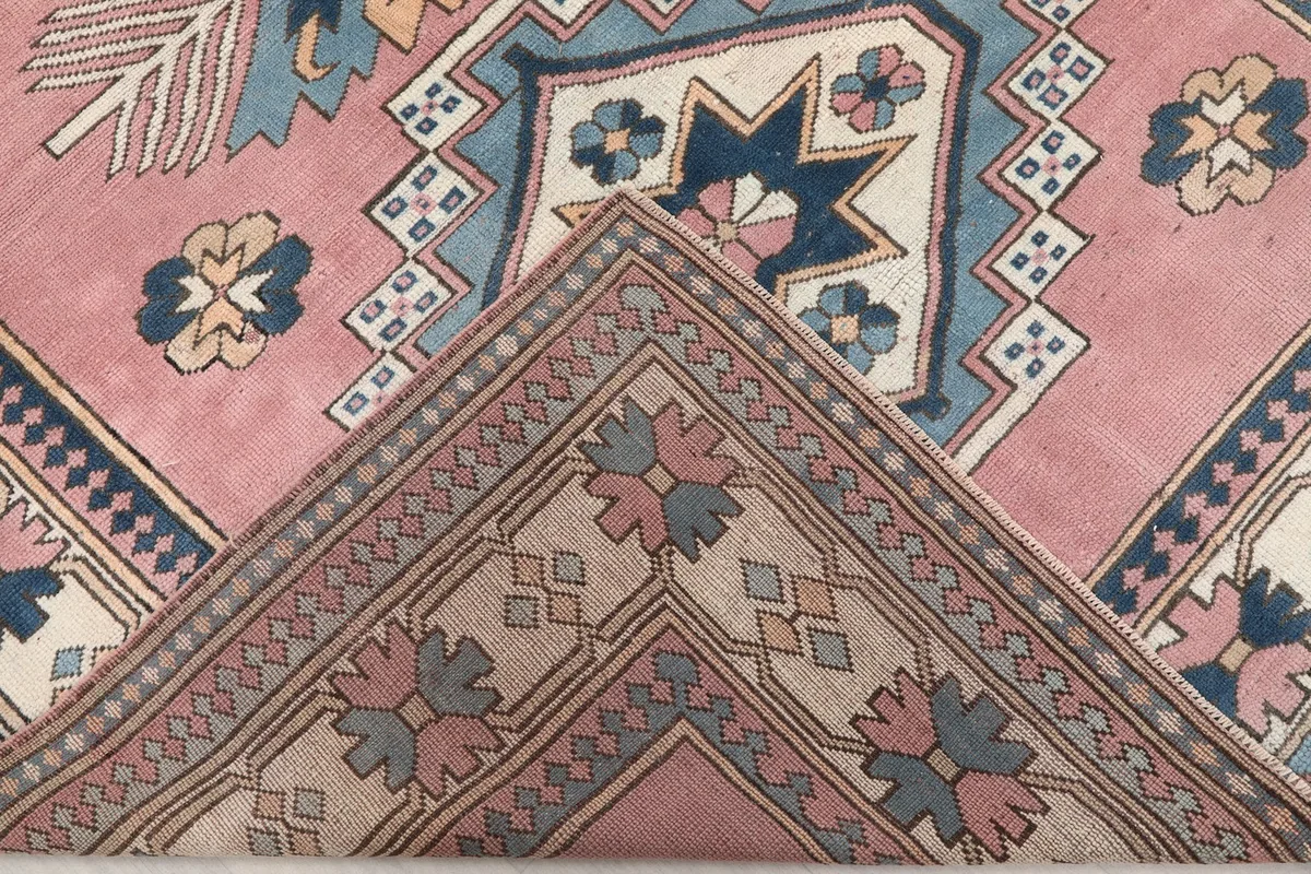 Corner of the rug folded back to reveal the cotton foundation and the reverse side of the hand-knotted wool.