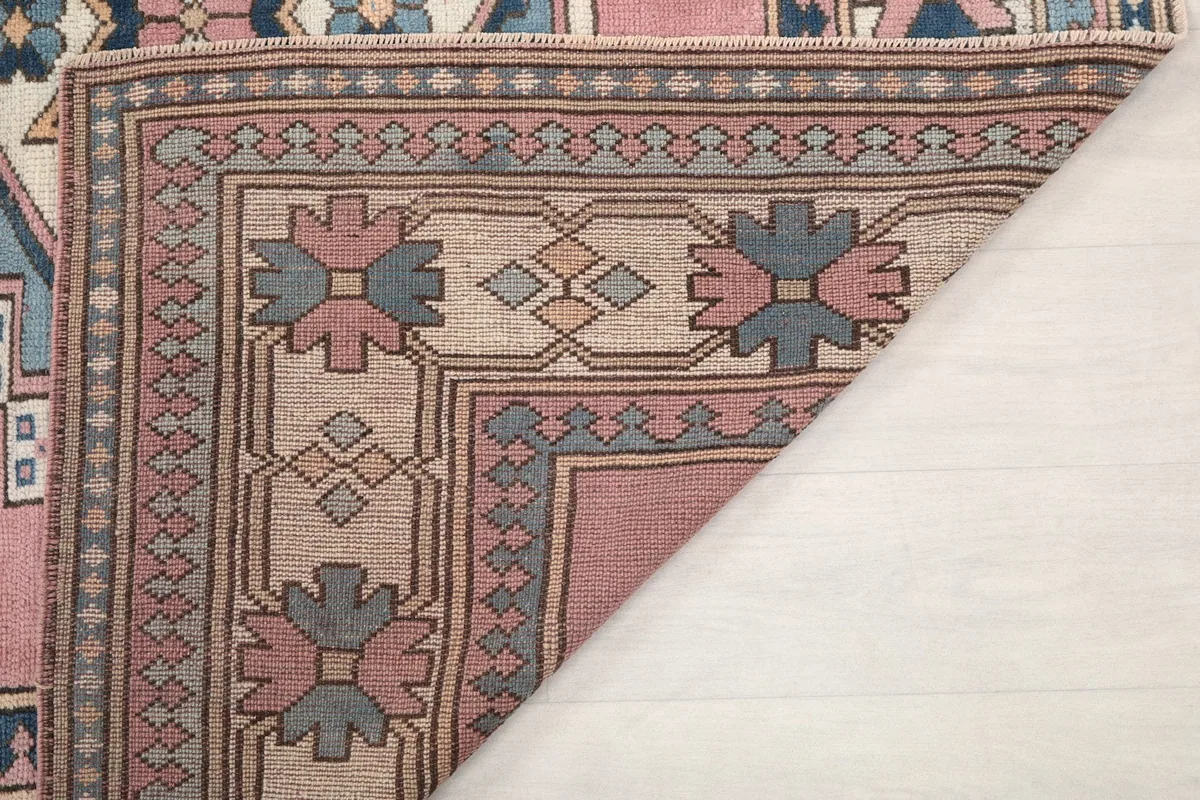 Another view of the rug's corner folded, showing the quality of the back and the consistency of the weave.