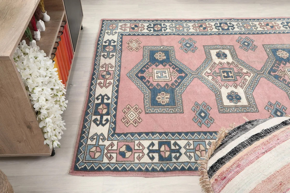 Angled shot of the rug's design and colors next to a wooden cabinet