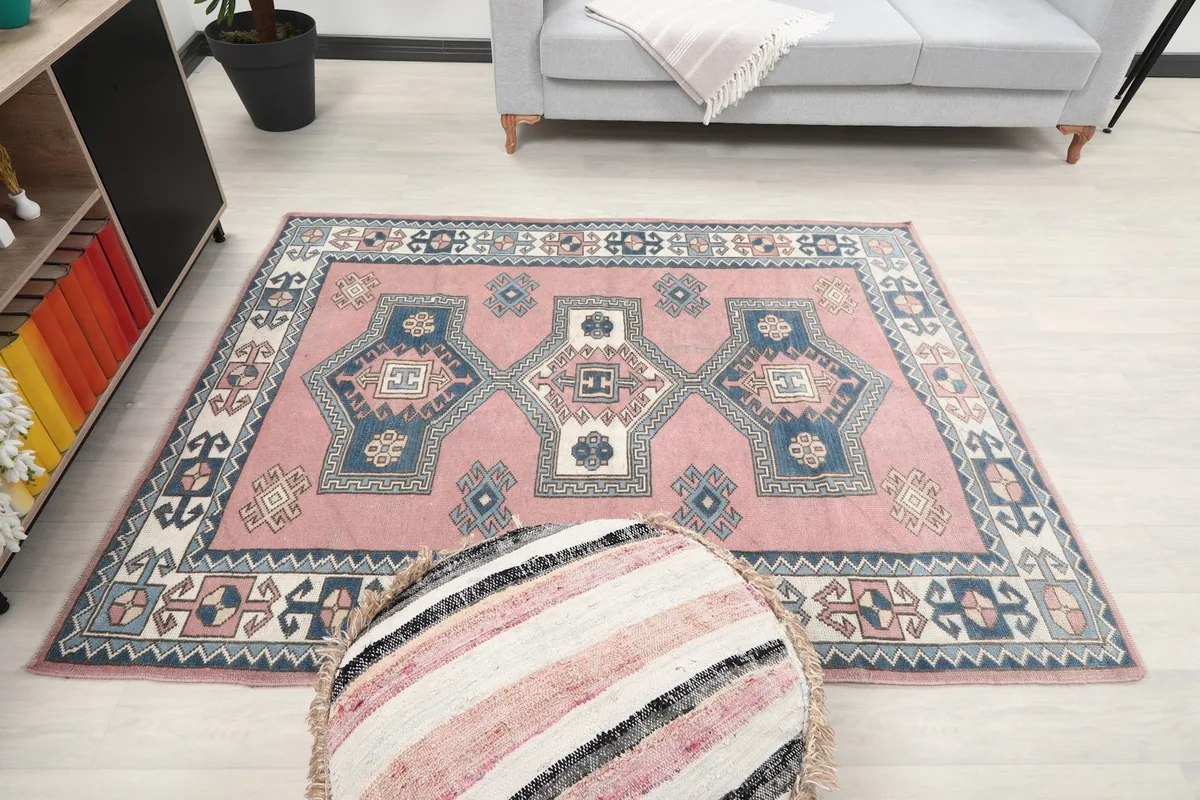 Full room view of the rug, ottoman, and sofa from a slightly different angle
