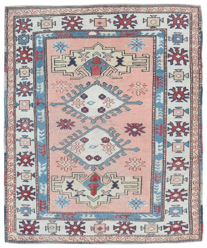 Full overhead view of the 4'9" x 5'9" vintage pink geometric Anatolian rug on a white background