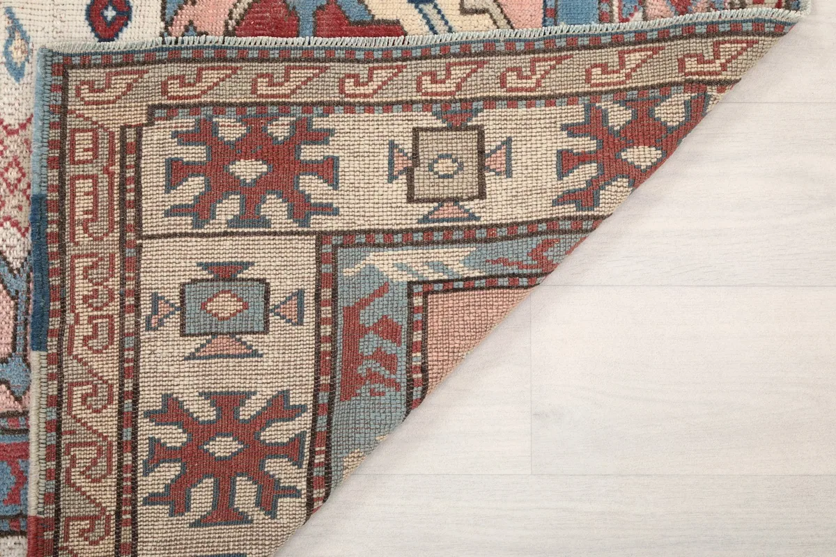 Underside view of the rug's corner, showing the hand-knotted cotton foundation