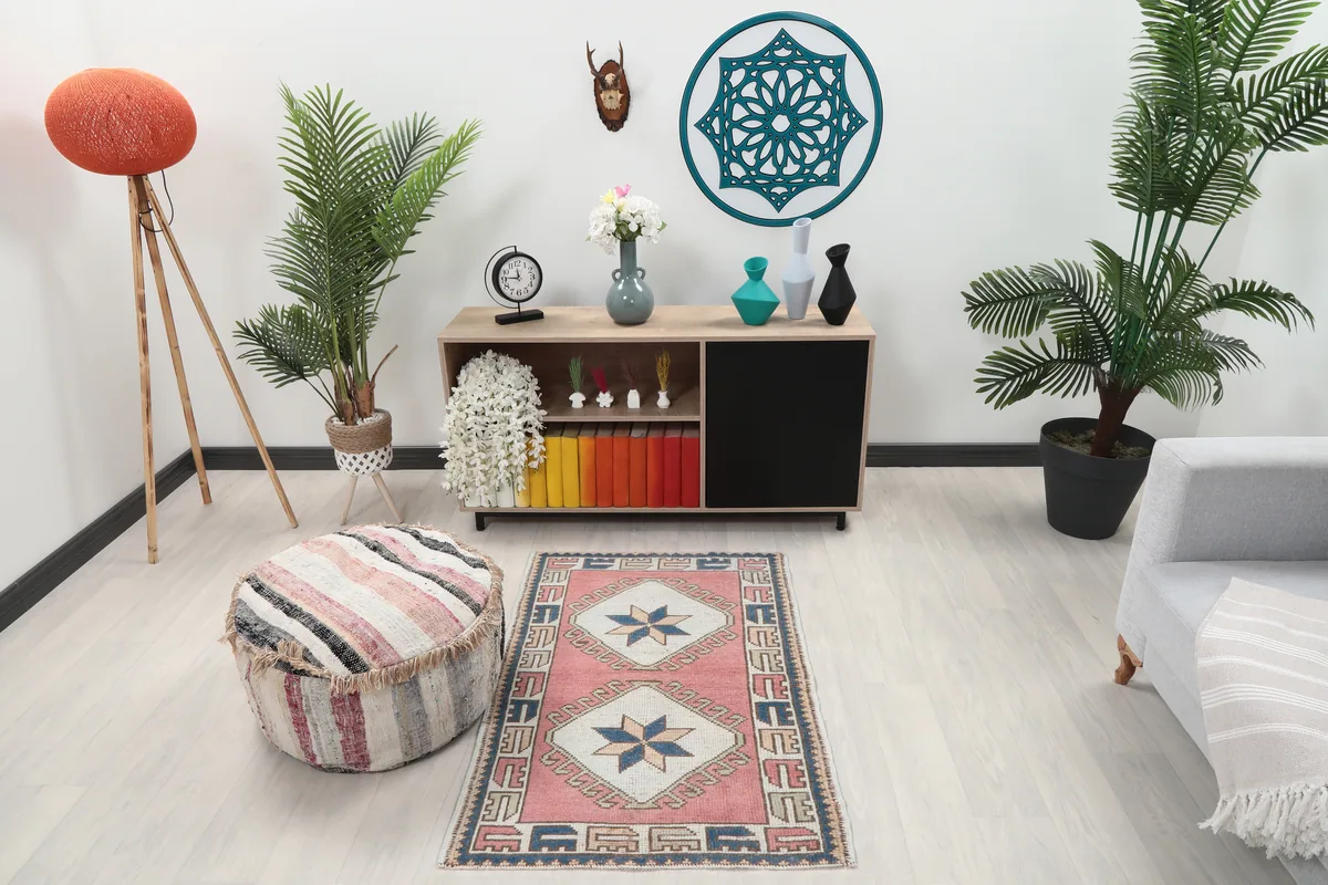 Rose Geometric Star Rug in a living room setting, showcasing its size and colors against light flooring.