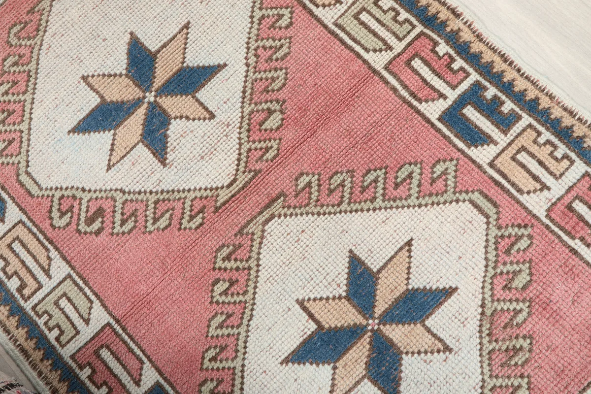 Rose Geometric Star Rug, close-up of the central rose field and an ivory medallion with a navy and beige star motif.