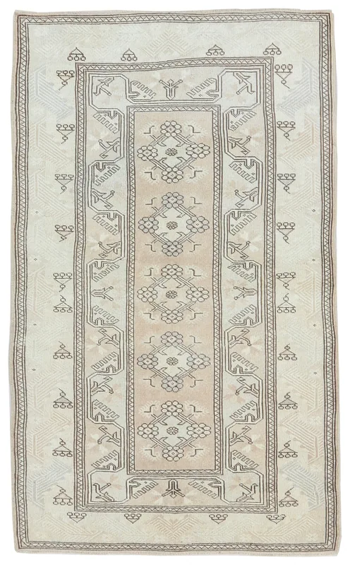 Full overhead view of the 3'10" x 6'8" ivory and beige vintage Anatolian rug with tribal geometric patterns.