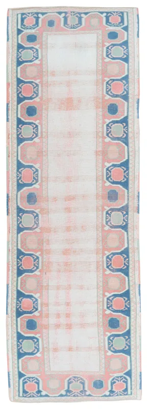 Full overhead view of the vintage Anatolian runner rug with ivory, rose, navy, and gray geometric patterns