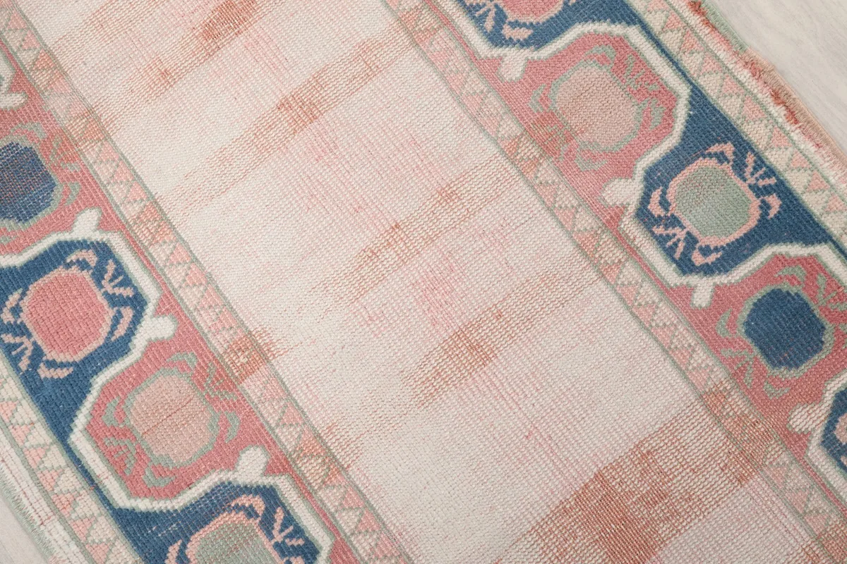 Close-up of the rug's central field with visible rose color variations and low pile